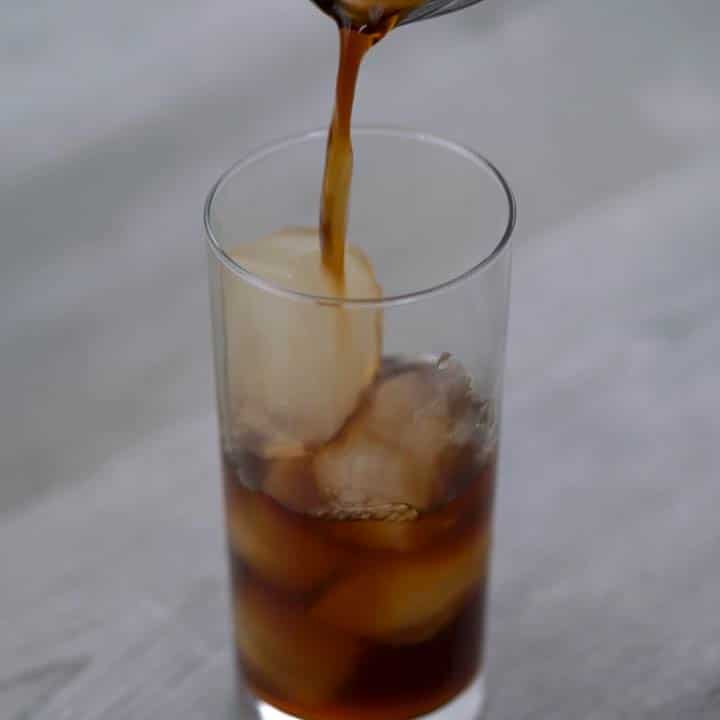 pouring chilled coffee over ice cubes