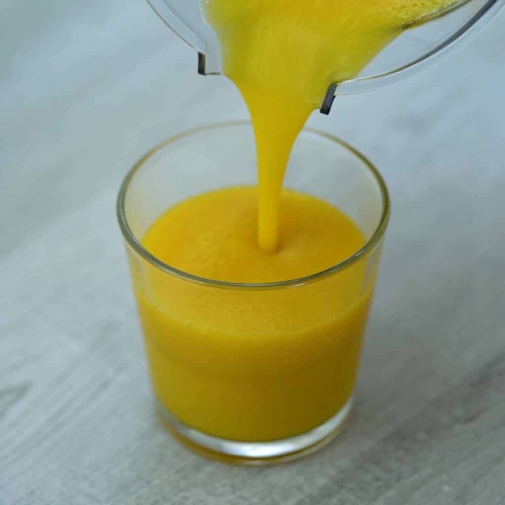 pouring mango juice into glass