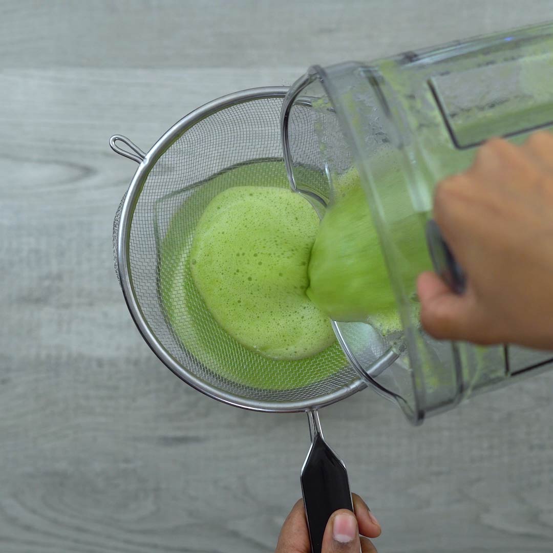 pouring the cucumber juice with mesh strainer