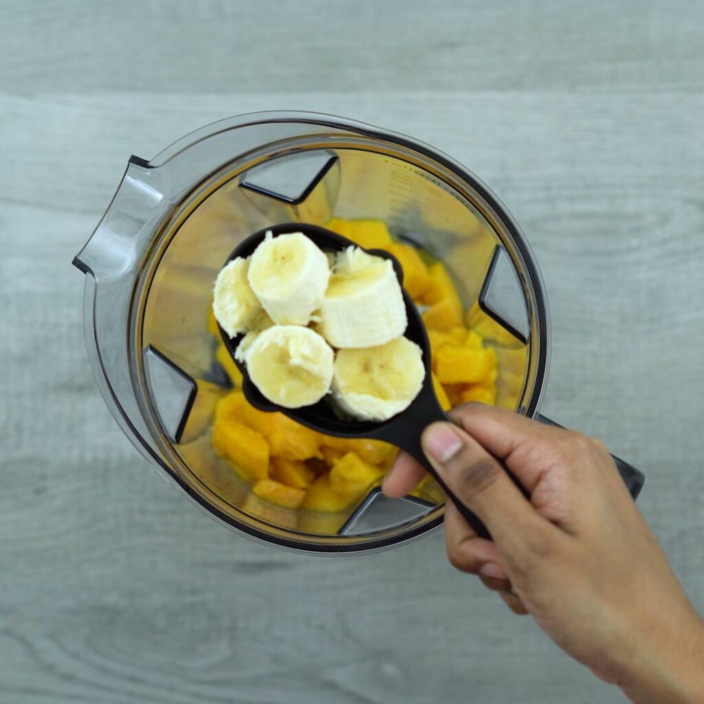 Adding Mango Smoothie ingredients into a blender