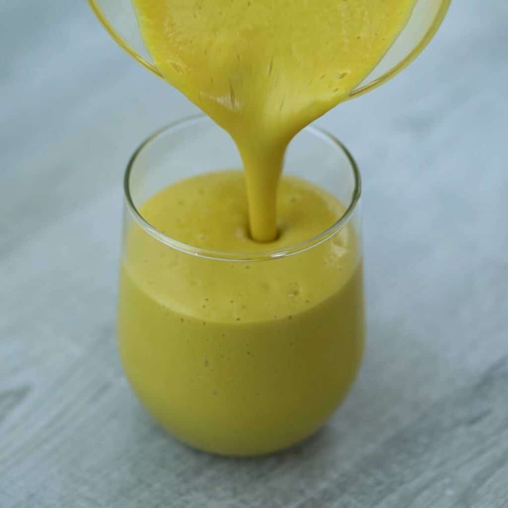 pouring the Mango Smoothie into a glass