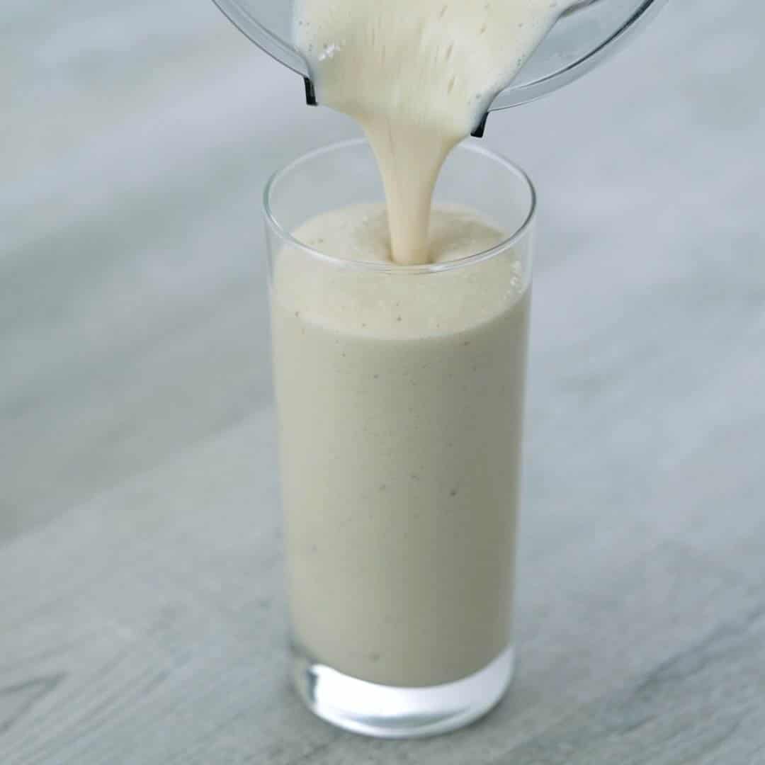 pouring banana protein shake into the glass