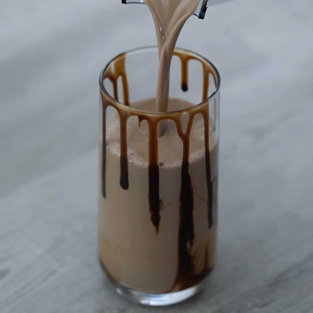 pouring chocolate milkshake into the serving glass