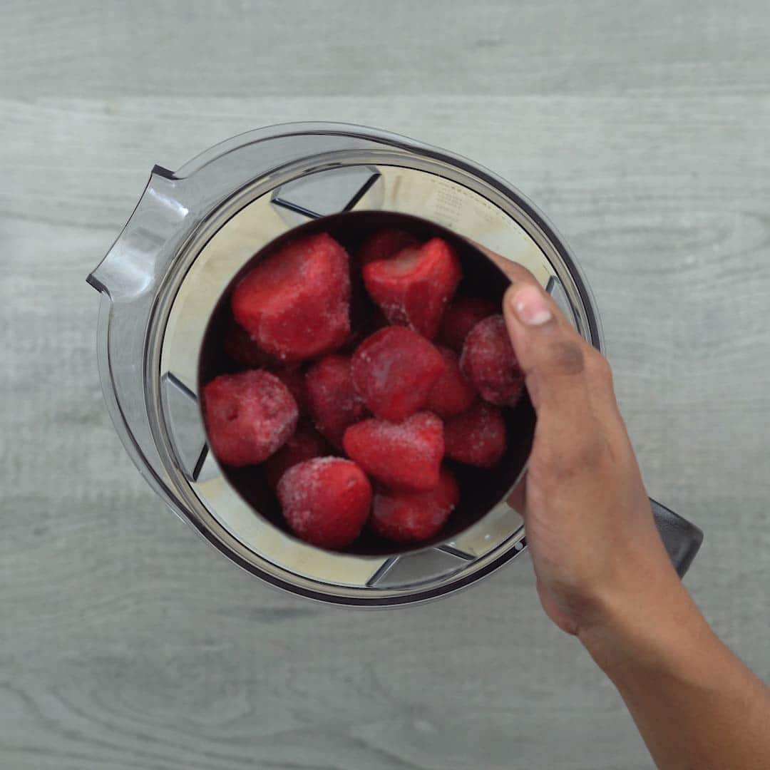 Adding strawberries, ice cream and milk into jar
