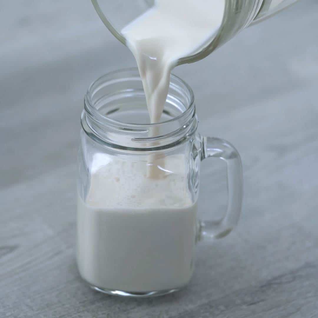 pouring the almond milk into a serving glass