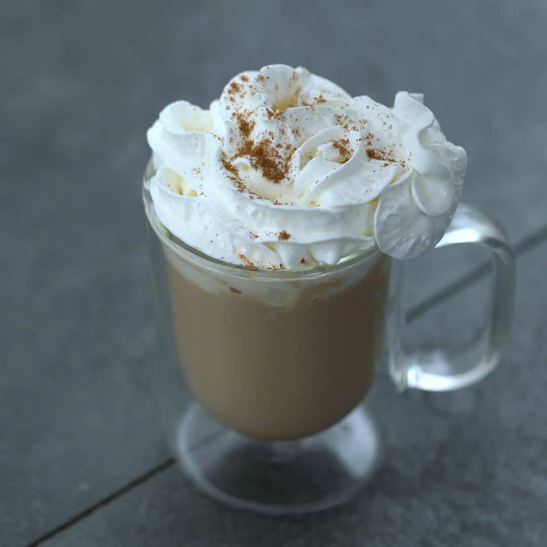 Pumpkin spice latte topped with whipped cream and spice powder