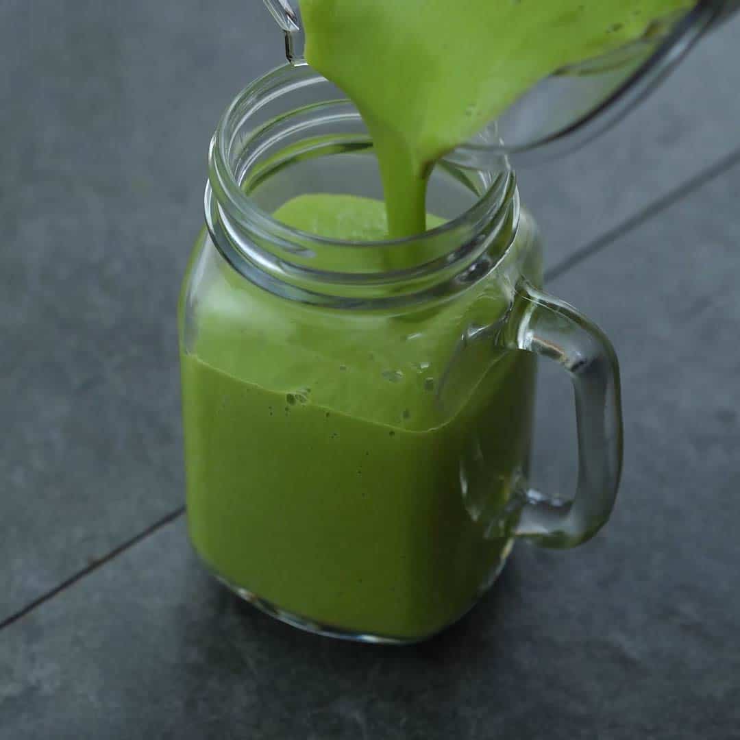 pouring avocado smoothie into serving jar