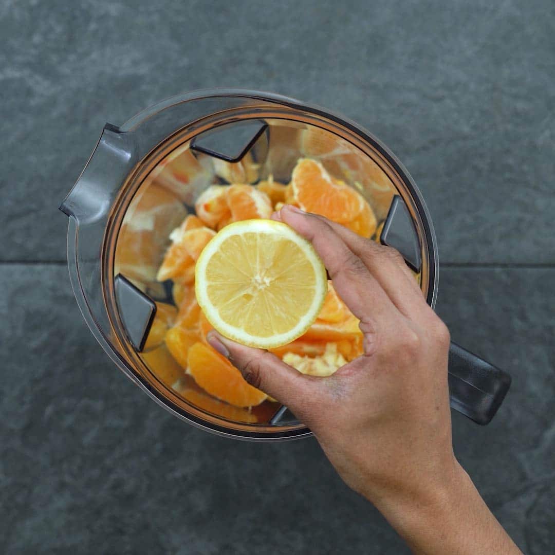 adding lemon juice to the oranges in blender
