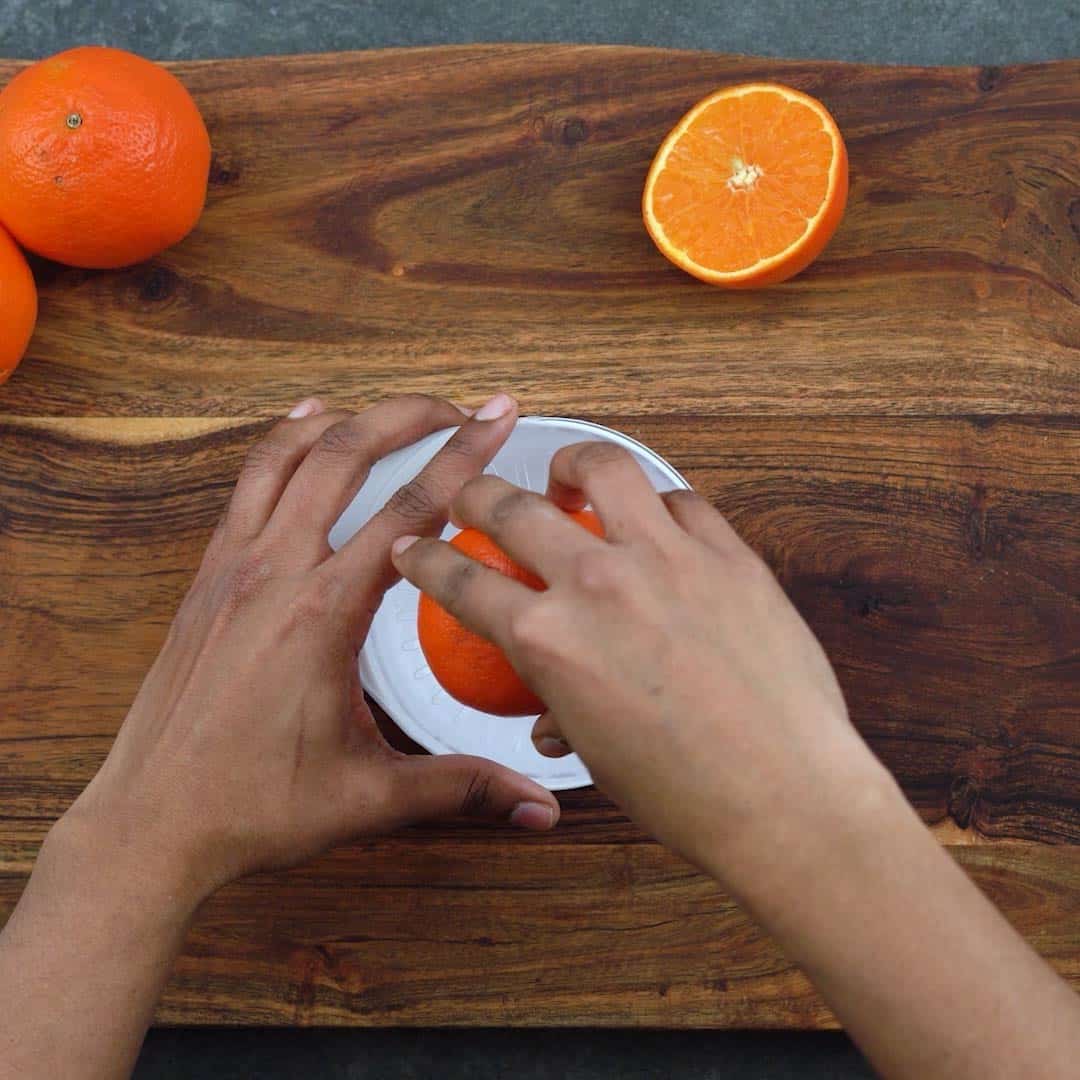 Squeezing Orange in a handheld juicer