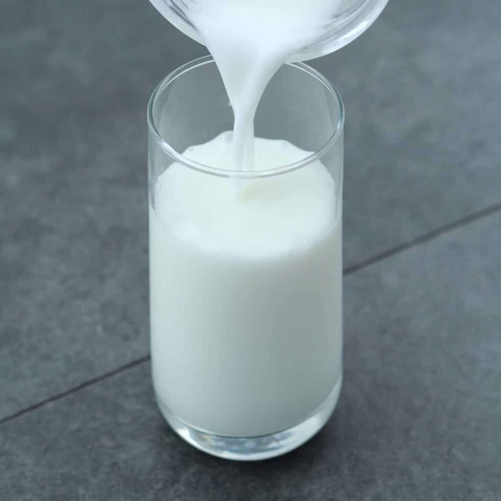pouring homemade buttermilk into serving glass