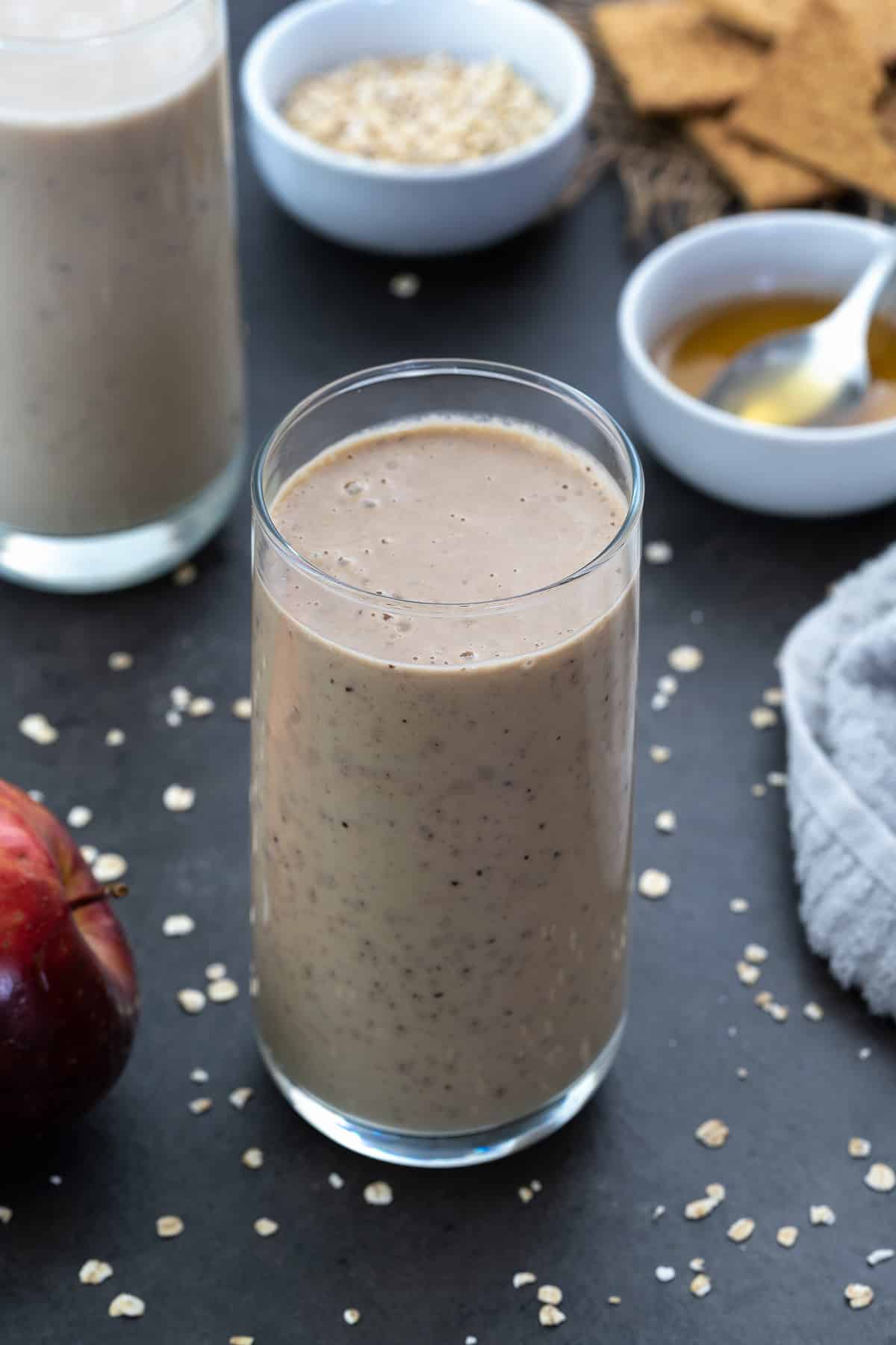 Apple Smoothie Served in a glass with honey and oats nearby