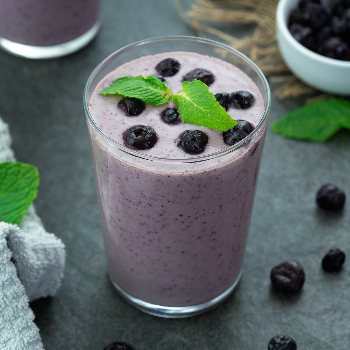 Blueberry Smoothie in a glass placed on a table with few ingredients around