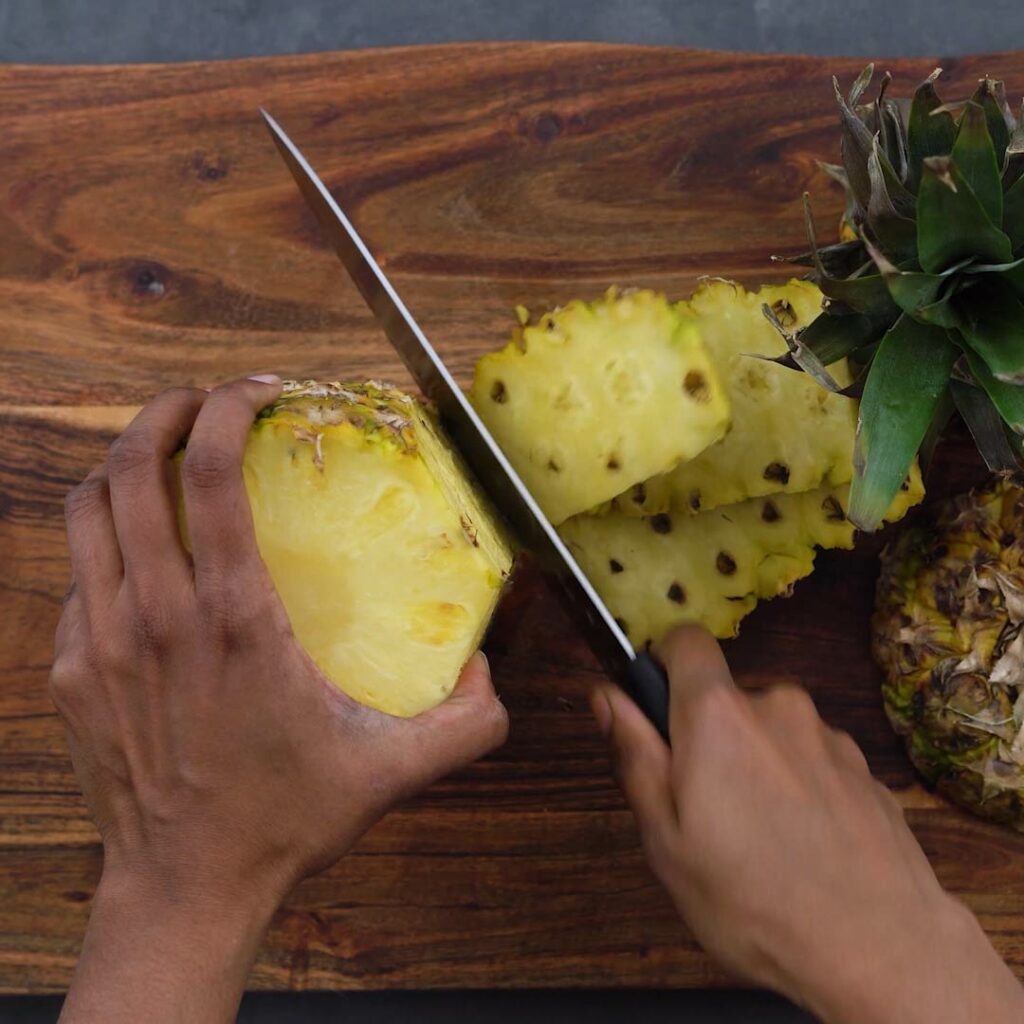 Slicing the peel of the pineapple