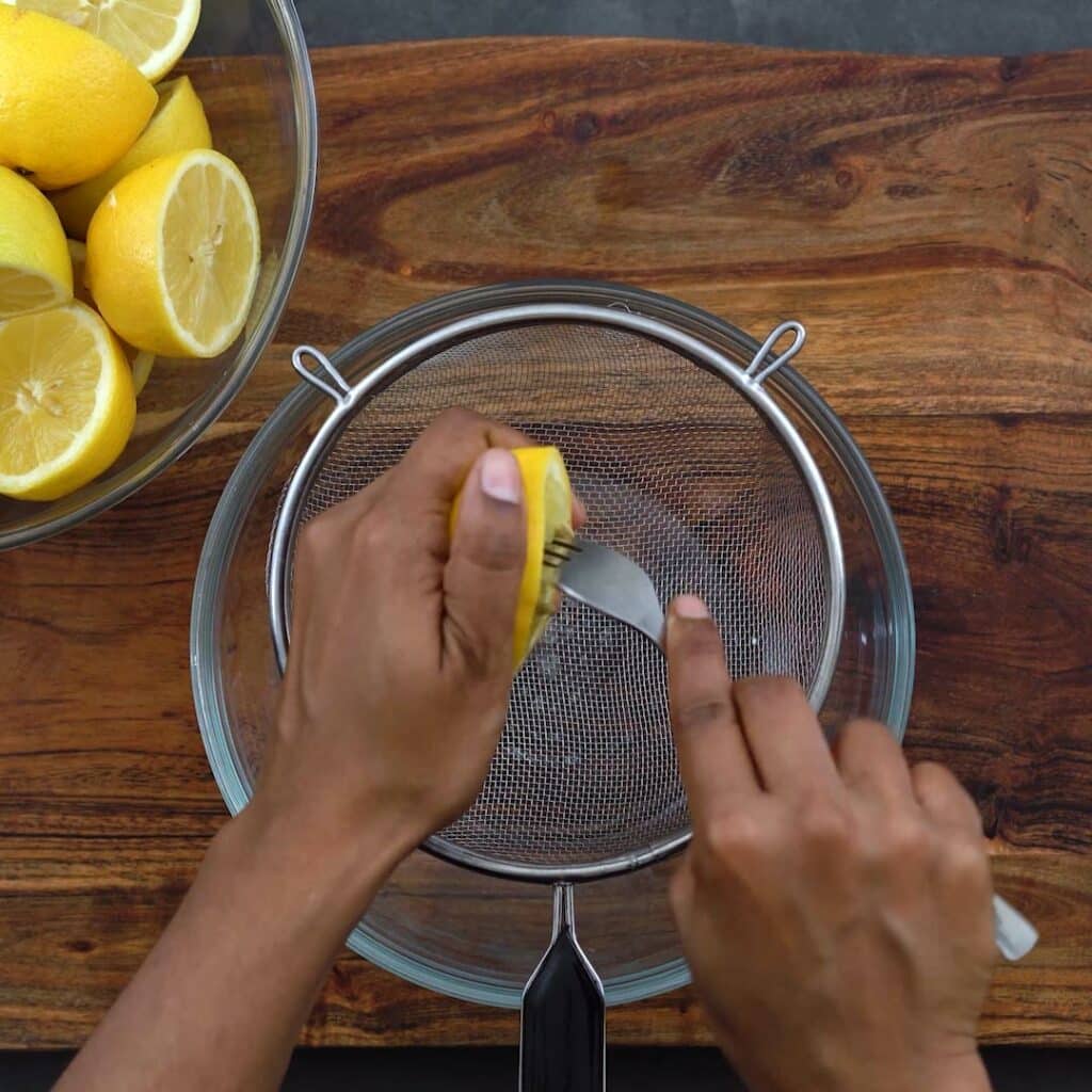 Squeezing the lemon juice using fork