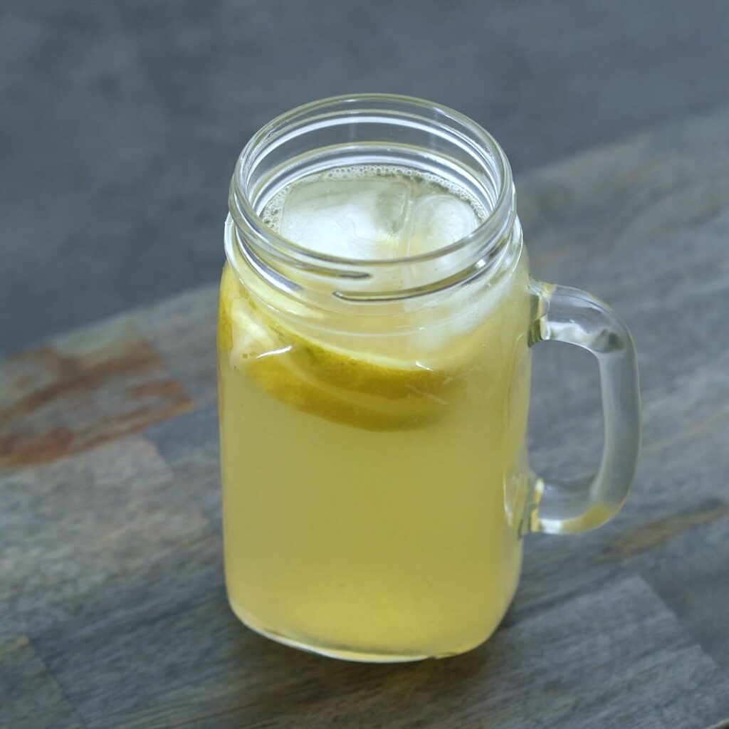 Lemonade served in cup with lemon slices and ice cubes