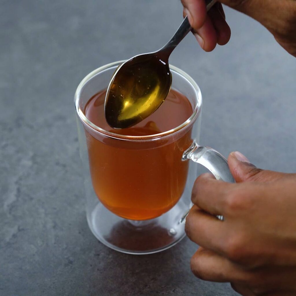 Adding honey to lemon tea