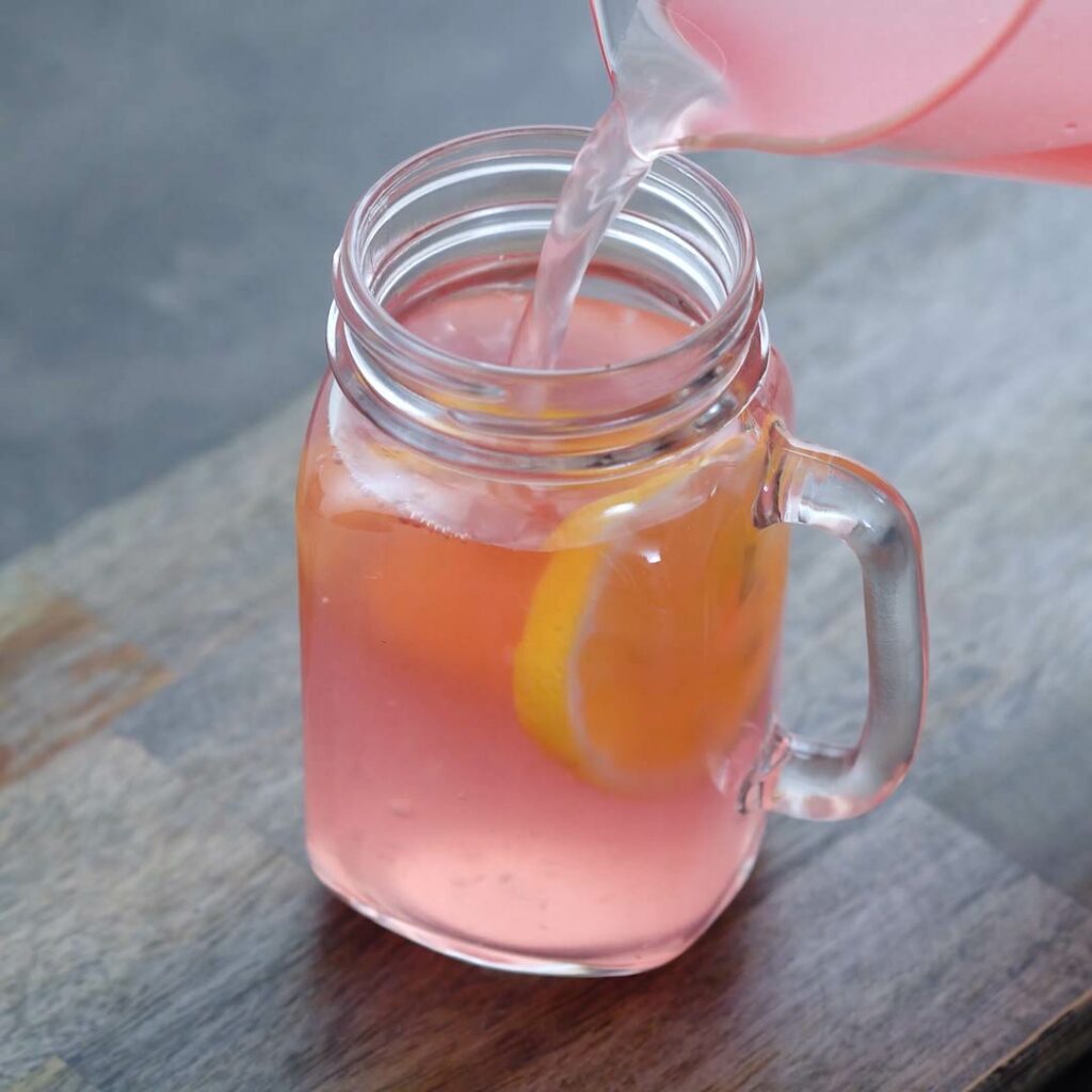 Pouring Pink Lemonade into a serving glass
