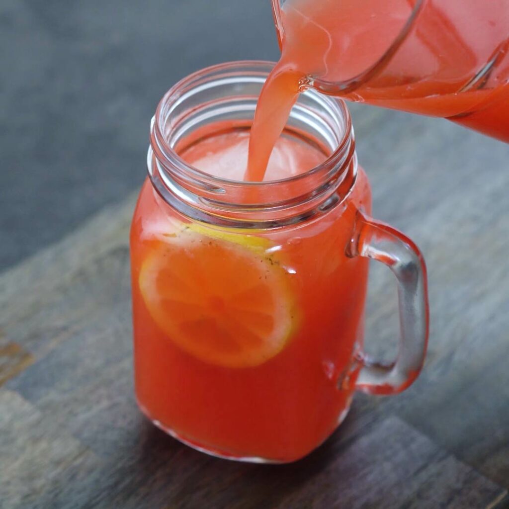 Pouring Strawberry Lemonade in a serving mug