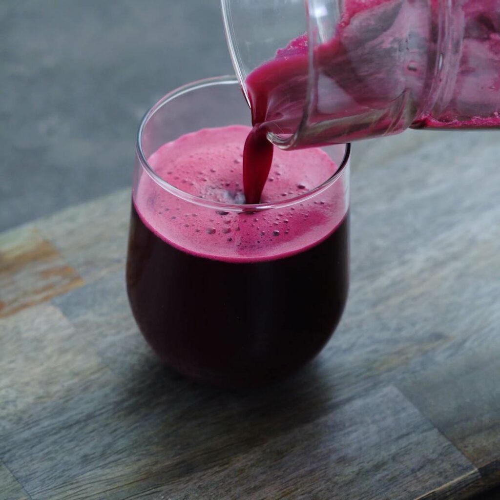 Pouring Beetroot juice into a serving glass