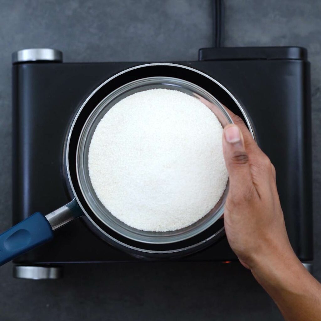 Adding a bowl of sugar into the saucepan