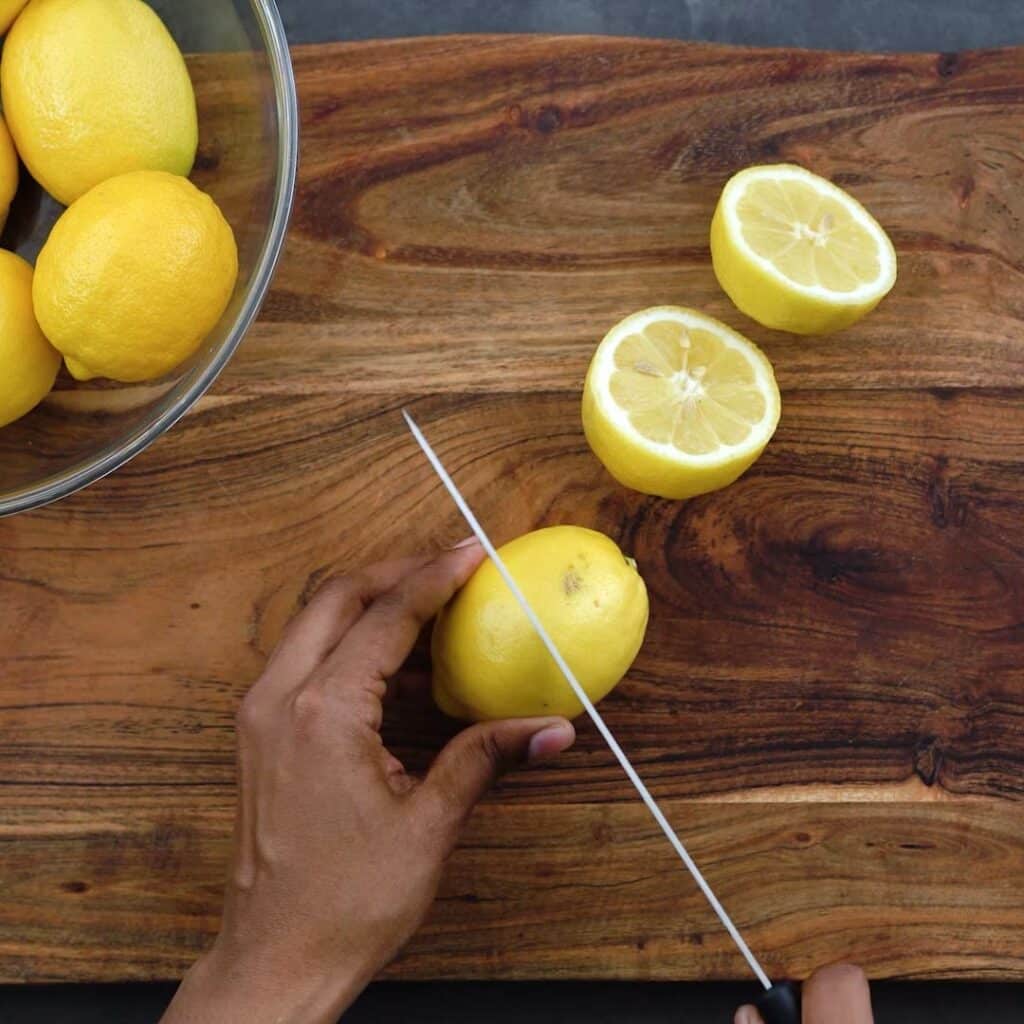 cutting the lemons in half with a knife